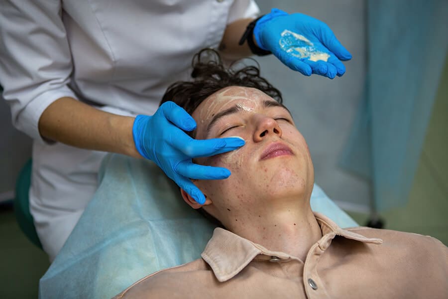 profissional fazendo uma limpeza de pele profunda para livrar cliente de cravos no rosto.