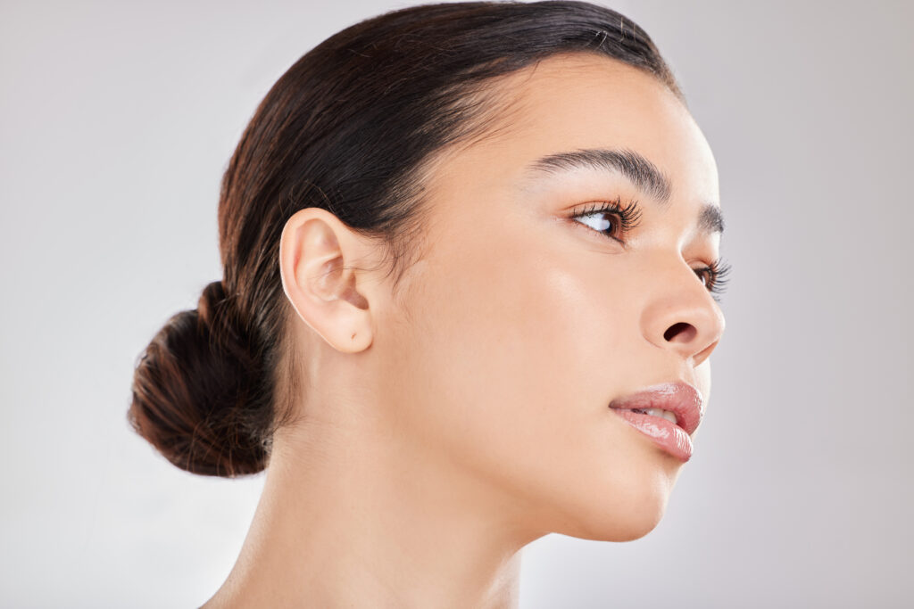 Glass Skin e Cloud Skin: entenda a diferença entre eles e como conquistar 2 Mulher com rosto levemente virado para a direita, com cabelo preso e com o rosto com efeito de cloud skin.